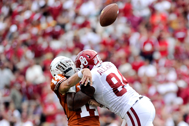 <p>David Ash (14) is manhandled by Oklahoma’s Frank Alexander (84) in last year’s Red River Rivalry. This season Ash and the Longhorns bring a new-found confidence to Dallas (Daily Texan file photo).</p>
