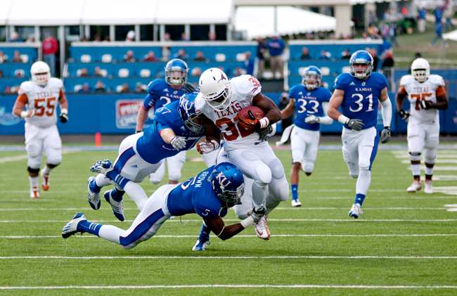 <p>Jonathan Gray (32) is corraled by Kansas defenders during the Longhorn's 21-17 win over Kansas in Lawrence last weekend. Gray rushed for a career-high 111 yards on 18 carries. </p>
