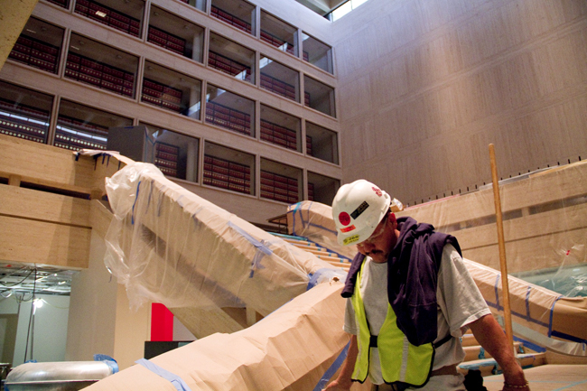 <p>A construction worker carries supplies down the staircase in the Great Hall of the LBJ Presidential Library. The library is in the final phase of a major redesign and will reopen on Dec 22, which would have been Lady Bird Johnson’s 100th birthday (<span style=