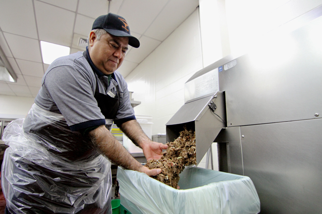 <p>Remedios Avila cleans the compost machine twice a day with wet cardboard. The Division of Housing & Food Service has composted over 250 tons of food waste between September 2011 and September 2012.</p>
