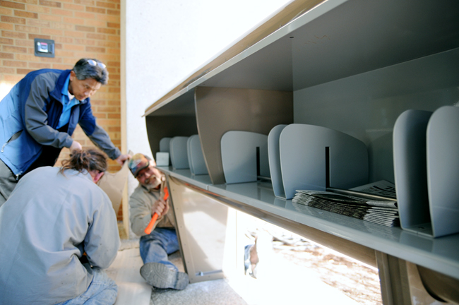 <p>Belo Center project manager Pawn Chulavatr and workers install a newsbox outside of the Belo Center Thursday morning. The newstand will house six newpapers, including The Daily Texan, The Dallas Morning News and the Austin-American Statesman.</p>
