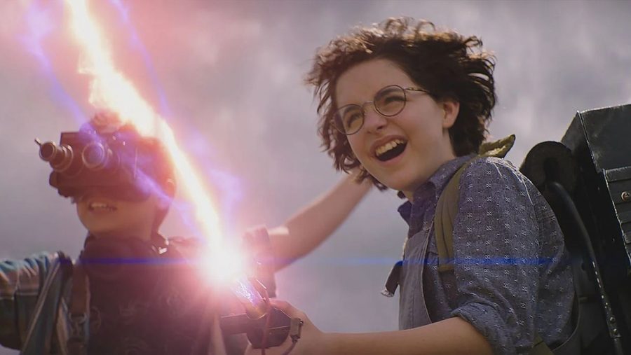 Phoebe (McKenna Grace) and Podcast (Logan Kim) test out a proton pack in “Ghostbusters: Afterlife”
