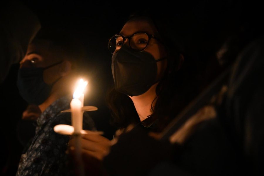 Design freshman Avery Fox holds a candle during a live performance of "Lean on Me."