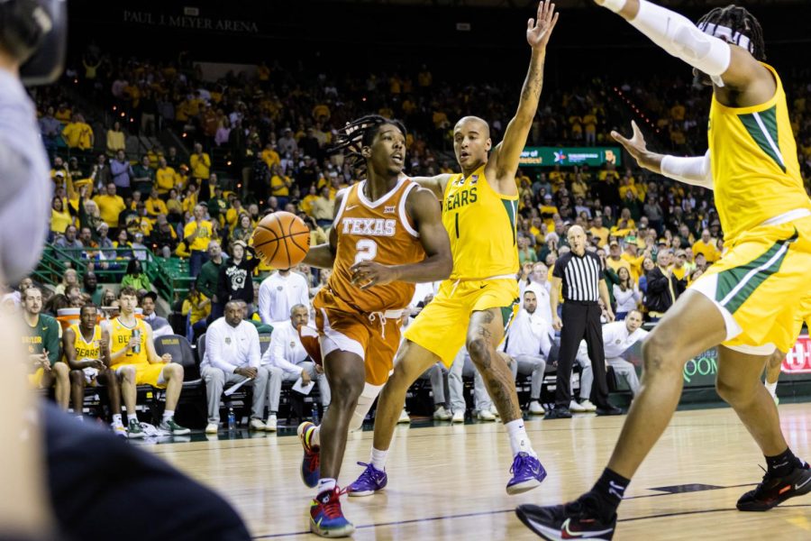 Senior Gaurd, Marcus Carr, attempts to score while being blocked by a Baylor basketball player. Texas played Baylor at Ferrell Stadium on February 12th, 2022.