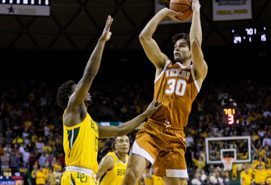 Junior+Forward%2C+Brock+Cunningham%2C+attempts+a+3+point+shot+while+being+blocked+by+a+Baylor+basketball+player.+Texas+played+Baylor+at+Ferrell+Stadium+on+February+12th%2C+2022.