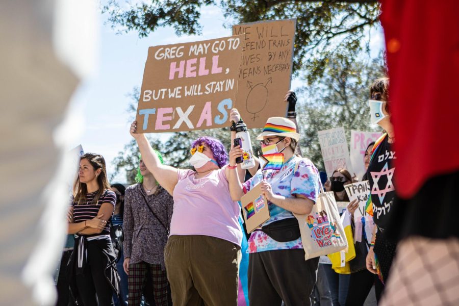 Hundreds of people wave their homemade signs and pride flags outside of the Texas State Capitol on March 1 in protest of Gov. Greg Abbott’s restrictions on transgender youth. 