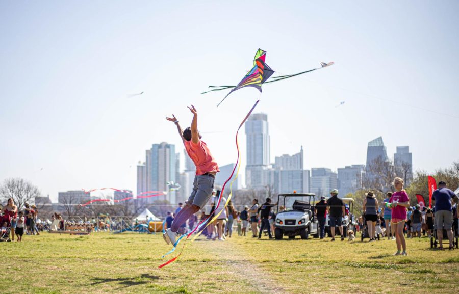 A festivalgoer jumps in the air to launch a kite at Zilker Park during Austins annual kite festival. This is the first time since 2019 that the festival has taken place in person. 