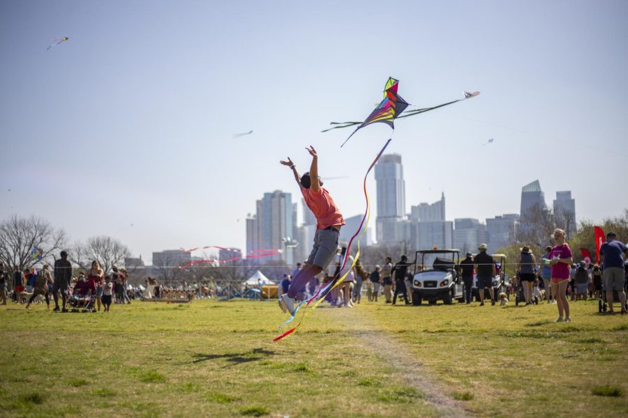 A festival-goer jumps in the air to launch a kite at the Kite Festival on April 3, 2022.
