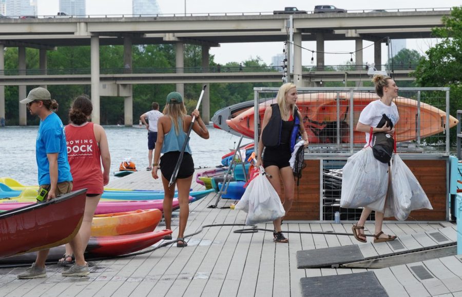 Volunteers help carry bags of trash away from Lady Bird Lake on April 22, 2022. Rowing Dock partnered with local Austin organizations to host an Earth Day clean up event that led to the removal of thousands of pounds of garbage.
