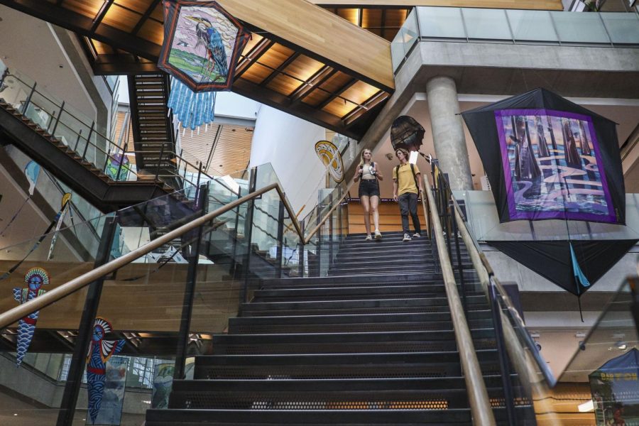 Two library-goers walk down a staircase in the Austin Central Library atrium. Located on W Caesar Chavez St, the Central Public Library is an architectural jewel of Austin.