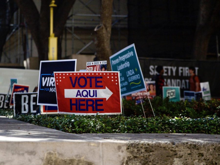 Campaign and voting signs crowd a grassy patch near the Peter T. Flawn Academic Center, one of two on-campus polling places at UT.
