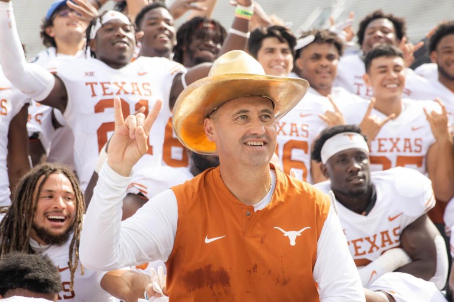 While wearing the gold hat, Texas coach Steve Sarkisian poses with his football team. On Oct. 8, 2022,  UT beat OU 49-0.
