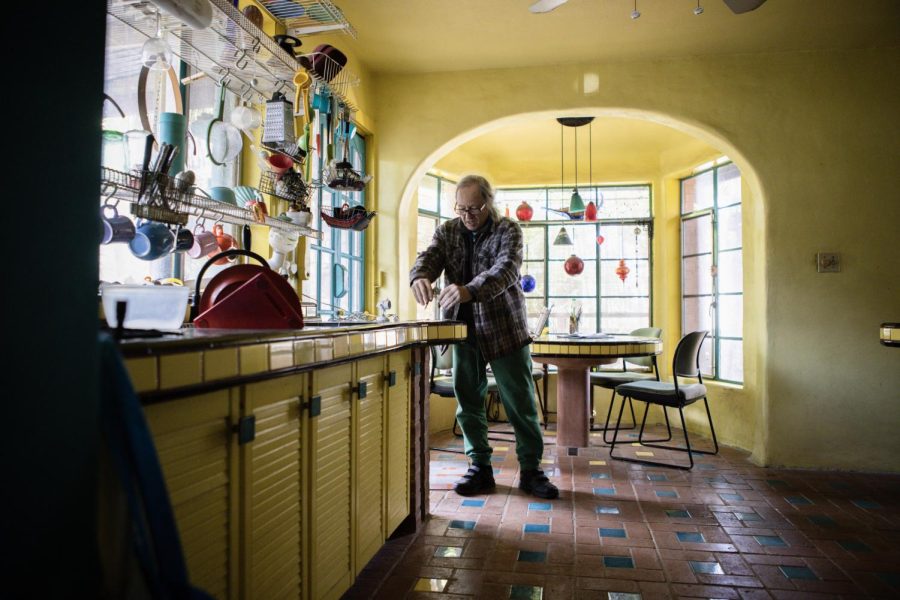 Talbot grabs a compass from his studio and tests its use in his kitchen. His kitchen is filled with bright colors and the design was solidified early in his life at Casa Neverlandia.
