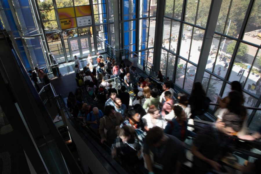 Festivalgoers travel up and down the escalators at the Austin Convention Center on March 13, 2023. 