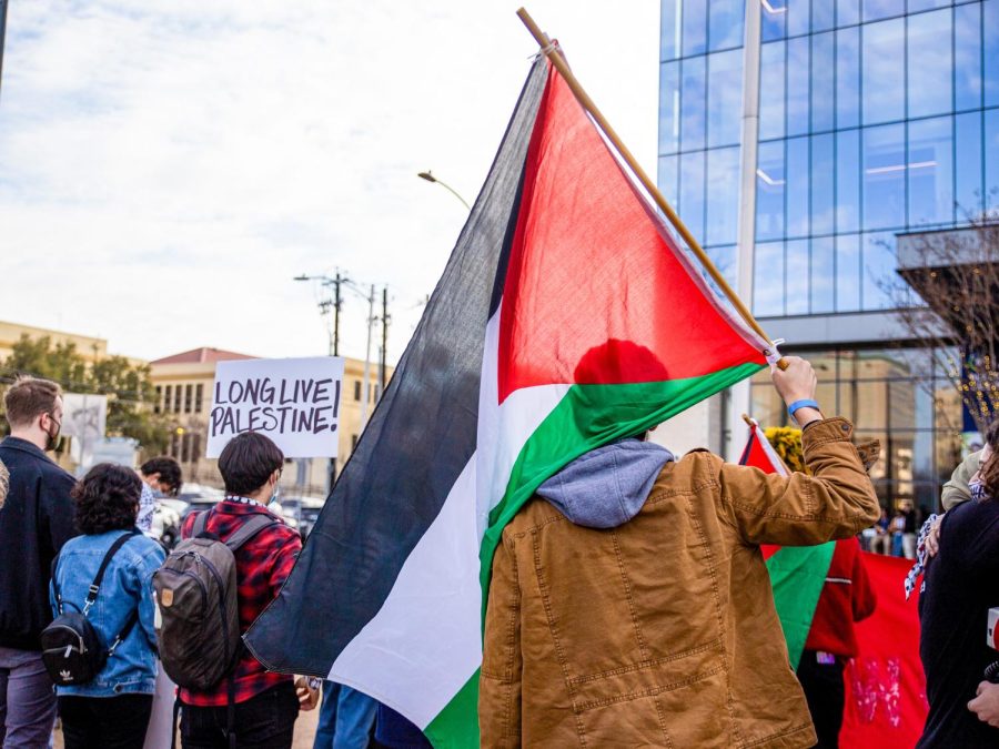 A protester holds a Palestinian flag. On Jan, 21, students and community members participated in a protest against the IAC National Summit at the Fairmont Hotel.