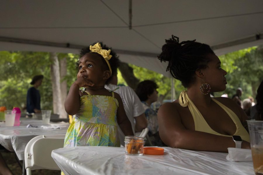 A child and her mother sit a table during a Juneteenth celebration at Eastwoods Neighborhood Park on June 19, 2023. The Eastwoods Neighborhood Association partnered with UTs Institute for Urban Policy Research & Analysis to hold the celebration.