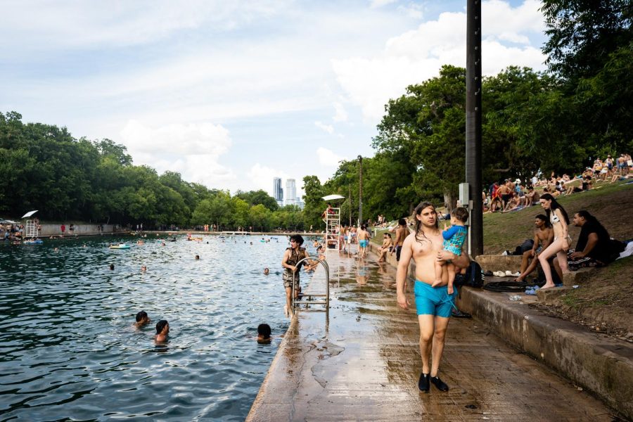 People swim and lounge at Barton Springs Pool on July 1, 2023. 