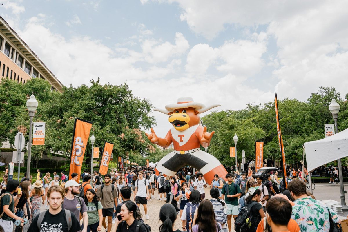 Students at the University of Texas at Austin walk in between classes through the Party on the Plaza event on Speedway on August 30, 2023.