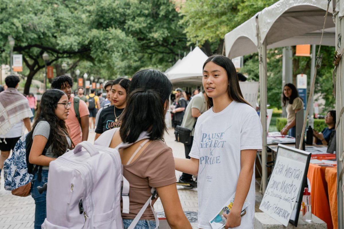 Angel Tung, representing Asian American Campus Ministry, speaks to prospective members at a booth on Speedway as a part of the University of Texas at Austins Party on the Plaza event on August 30, 2023.