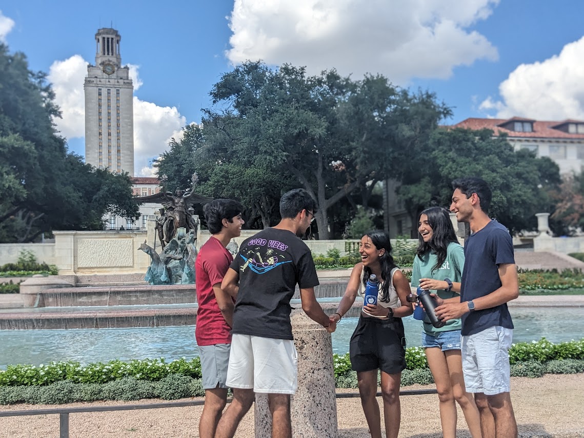 A group of Canfield Business Honors freshman socialize in front of Littlefield Fountain and enjoy the sunlight after a long bus ride on Sept. 04, 2023. They are just returning to campus following a Canfield Business Honors weekend retreat. 

