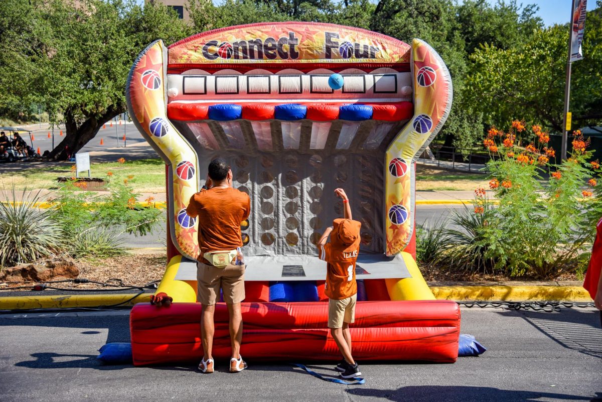 Father and son play the connect four basketball game on bevo boulevard on September 2, 2023. Connect four is one of the many family friendly activities out side the stadium including a zip line and a Ferris Wheel.