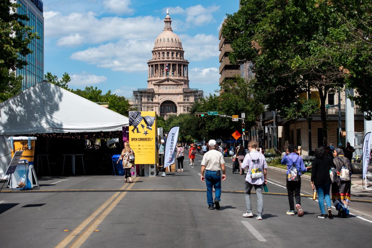 People walk down Congress street as panels continue for Texas Tribune Fest. Open Congress is a series of panels held in tents on congress street that are open to the public throughout the festival.