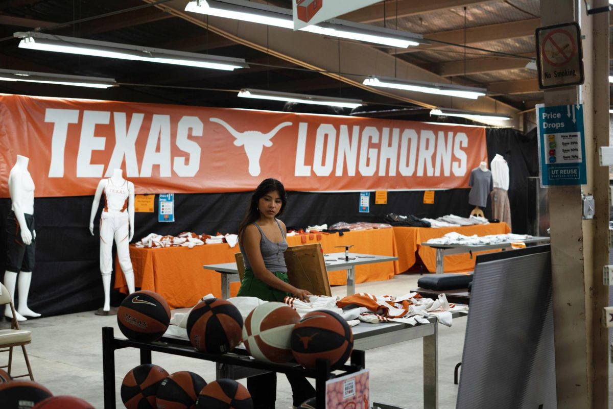 A+woman+looks+through+old+University+of+Texas+cheerleading+uniforms+at+the+UT+ReUse+store+on+Sept.+21%2C+2023.+