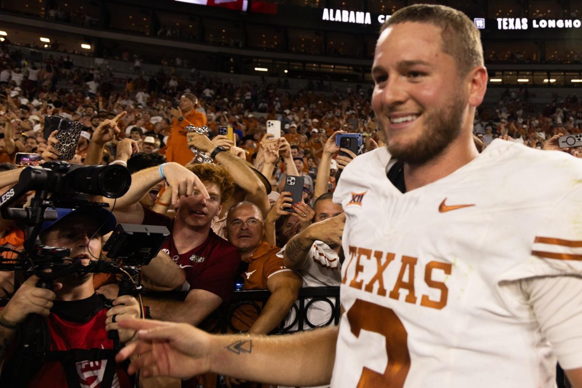 Texas quarterback Quinn Ewers smiles after the Longhorns win against Alabama on September 9, 2023. Alabama fans in the back did the common Horns Down gesture.