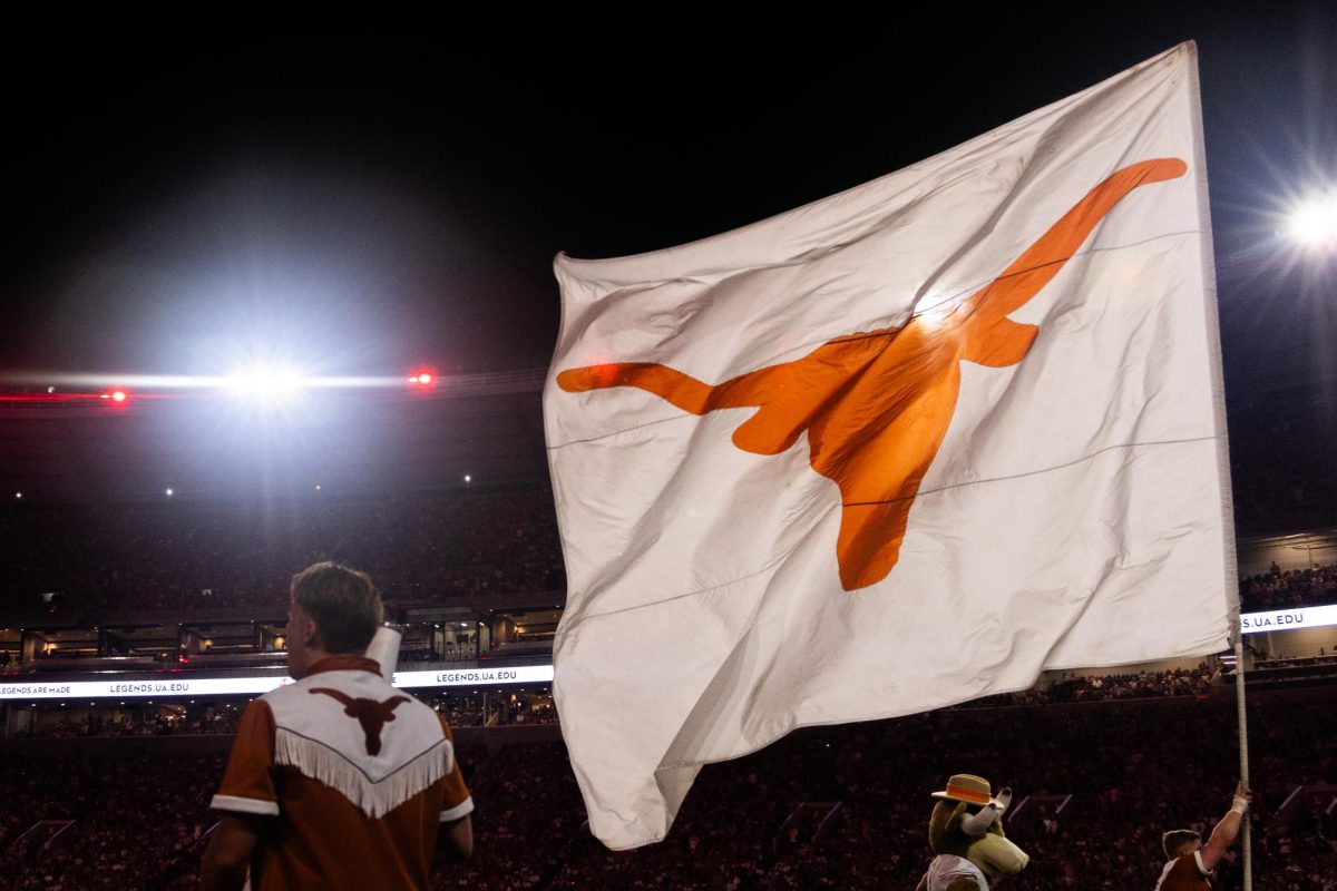 A flag with the Longhorns' symbol flies as a UT cheerleader carries it down the sideline at Bryant-Denny Stadium on September 9, 2023.