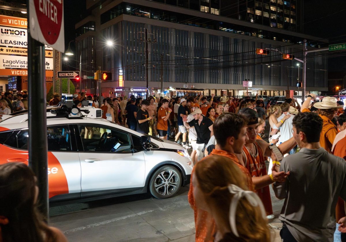 An autonomous Cruise car is stalled as students flood the intersection of of 24th and Nueces after UT beat Alabama on Sep. 9, 2023.