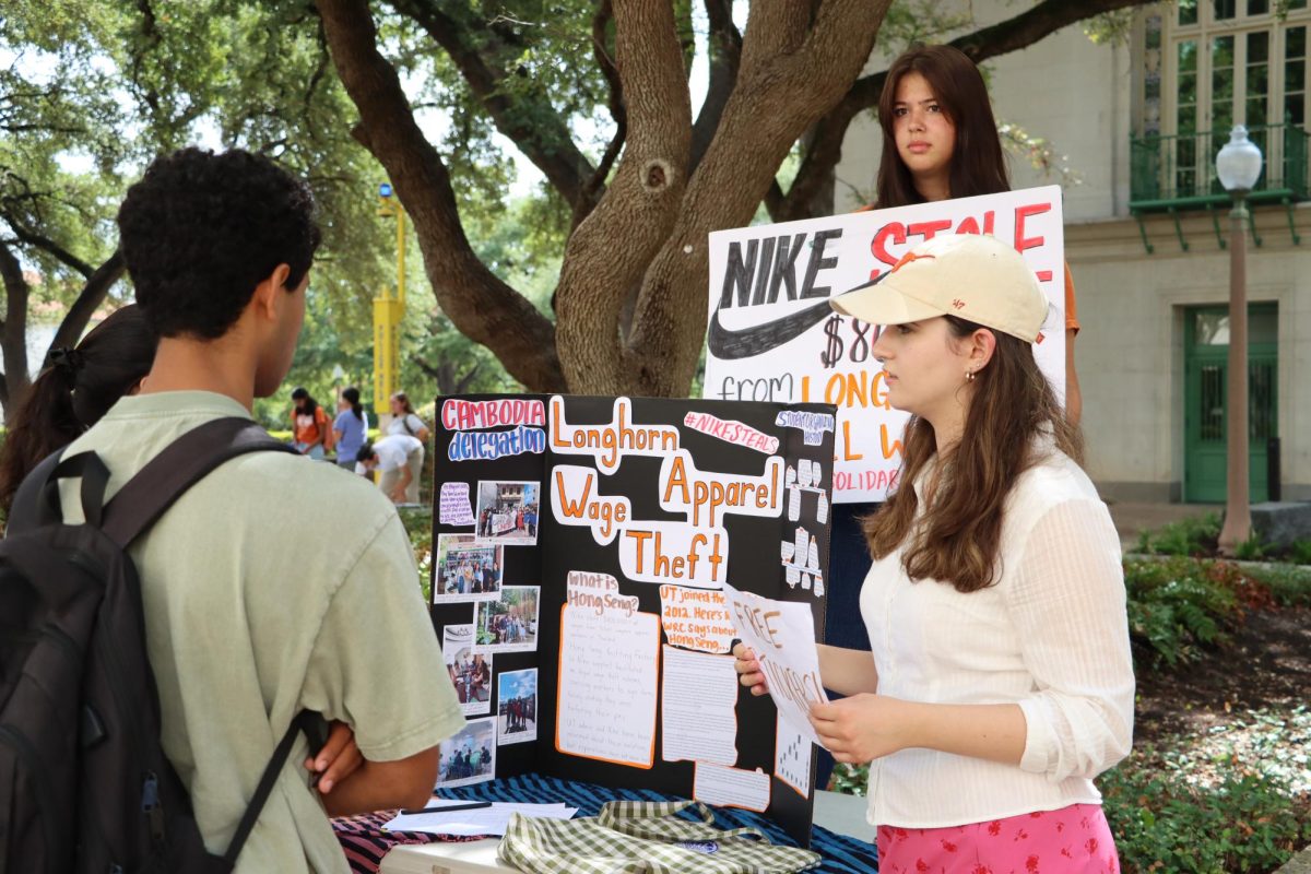 sophomores Erin Camelon and Aubrey McCabe inform junior Vivek Kogilathota about the Hong Seng Workers Solidarity Campaign on Sep. 15, 2023. The campaign is protesting against unfair wages for Nike UT apparel workers in Thailand.