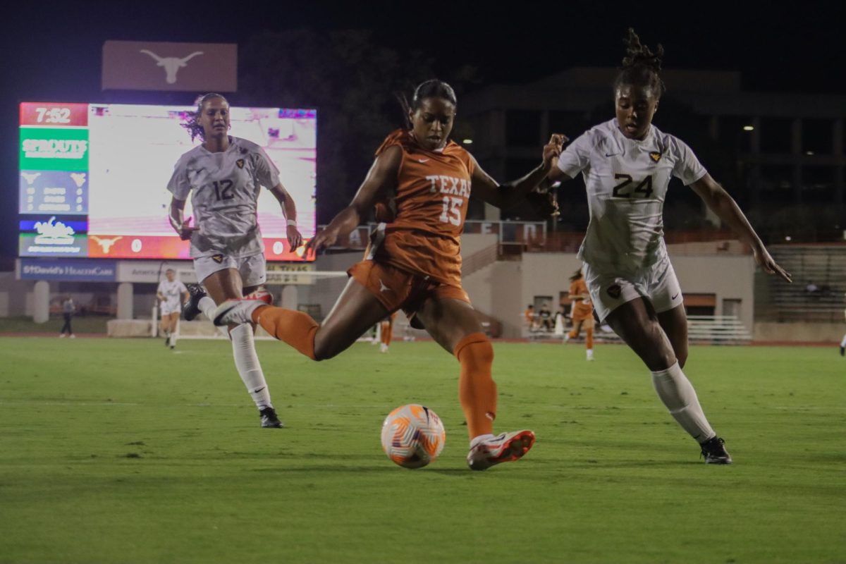 Texas forward Trinity Byars readies to kick the ball as WVUs midfielder May McCutcheon (left) and Nyema Ingleton (right) catches up to her. 