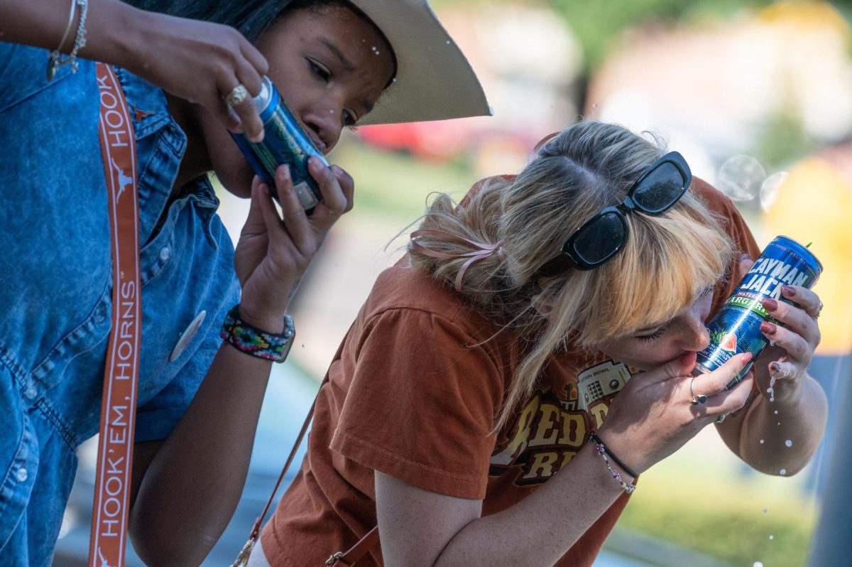 Early education–6th generalist senior Dianna Davis and environmental engineering major Jillian Holt drink Cayman Jack’s shotgun-style before approaching the Cotton Bowl entry gates at the Red River Rivalry game.