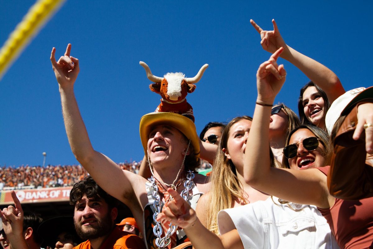 Biochemistry sophomore Jack Maddox, also known as Bevo Hat Guy, cheers alongside other fans during the Red River Rivalry game on Oct. 7, 2023.