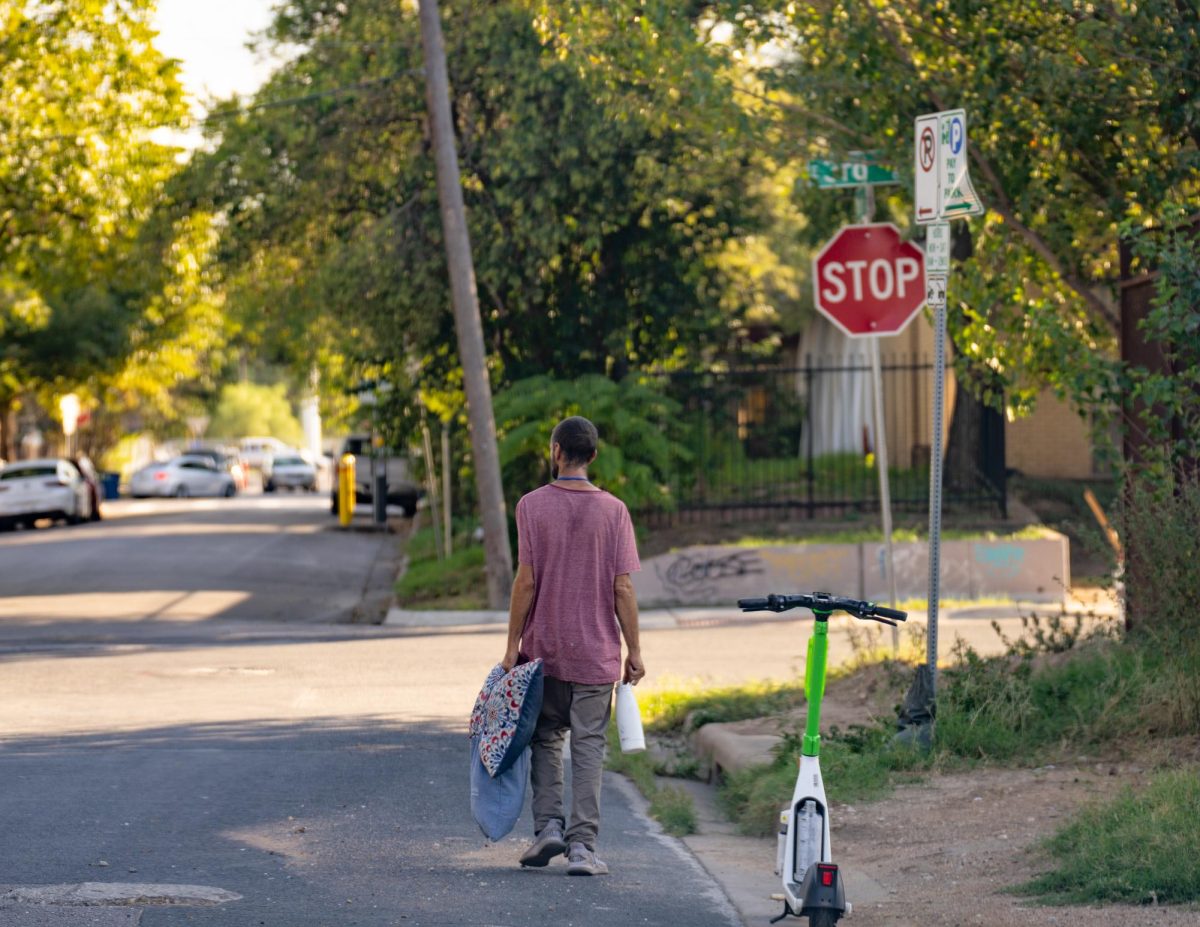 A unhoused man is seen walking with his belongings towards the intersection of East 2nd and Brushy Street on Septemeber 29, 2023.