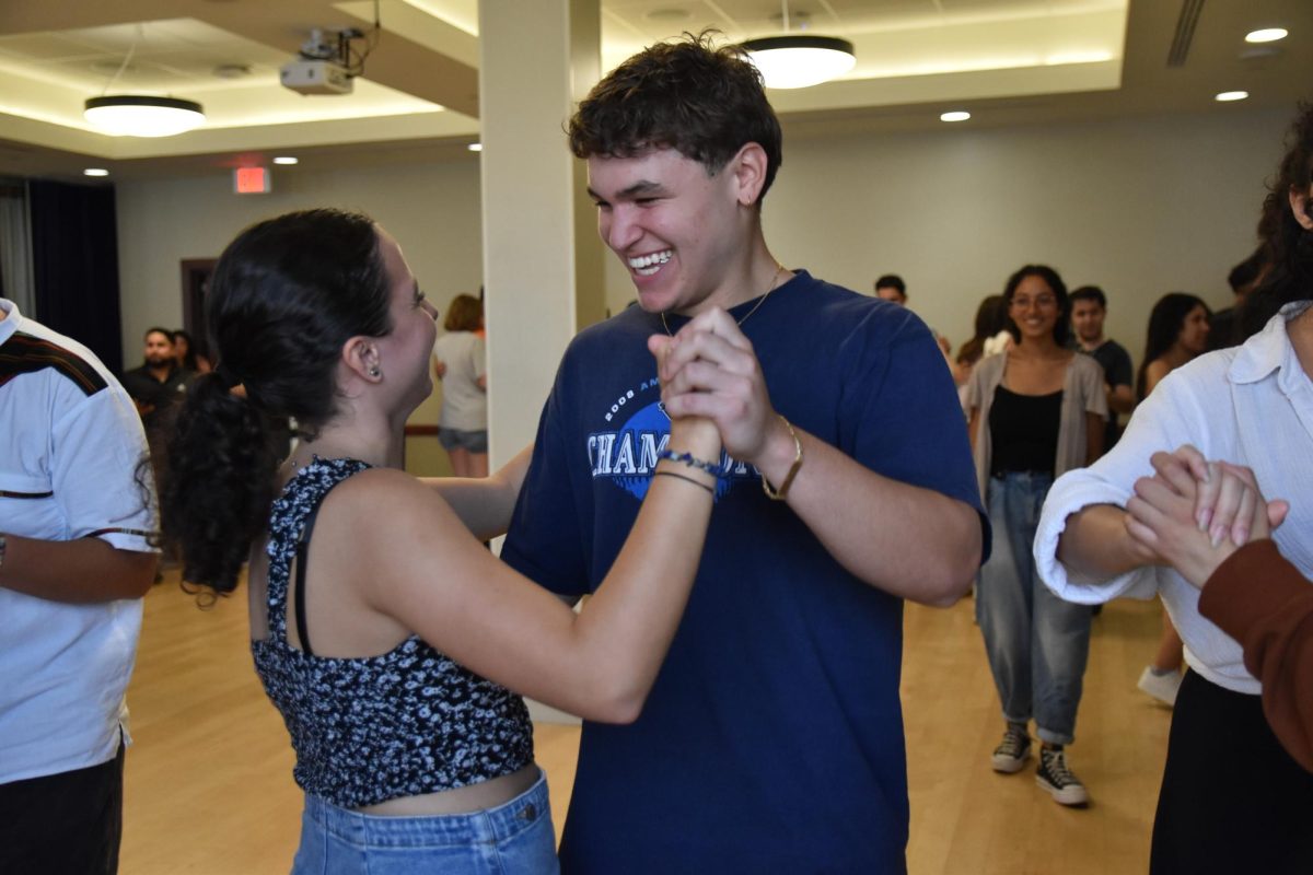 Current member of the Texas Latin Dance club, Mishell Mangus Ducloux, and Michael Wood laugh while trying to figure out the next dance move during the free dance class on Sept. 28th. 
