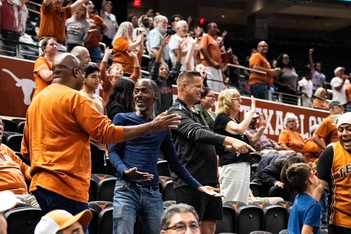 Fans in the stands support the women’s basketball team in their Orange vs. White scrimmage in the Moody Center on Oct. 24, 2023. A boy caught one of the free t-shirts that cheerleaders and Hook’em launched during half time.