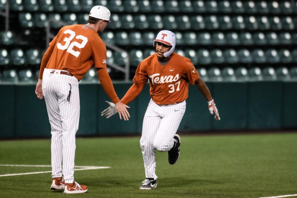 Freshman catcher Nik Sanders high-fives Senior pitcher Charlie Hurley at game two of the annual Fall World Series held at UFCU Disch-Falk Field on Nov. 3, 2023. Hurley acted as a coach for all three of the Orange vs. Stripes scrimmage games held.