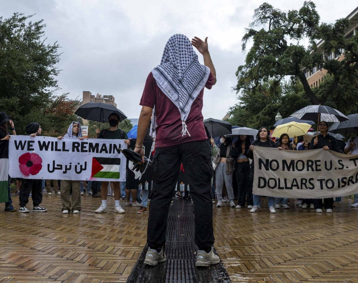 A Palestine Solidarity Committee member leads the crowd down Speedway to the Tower on Thursday's walkout.