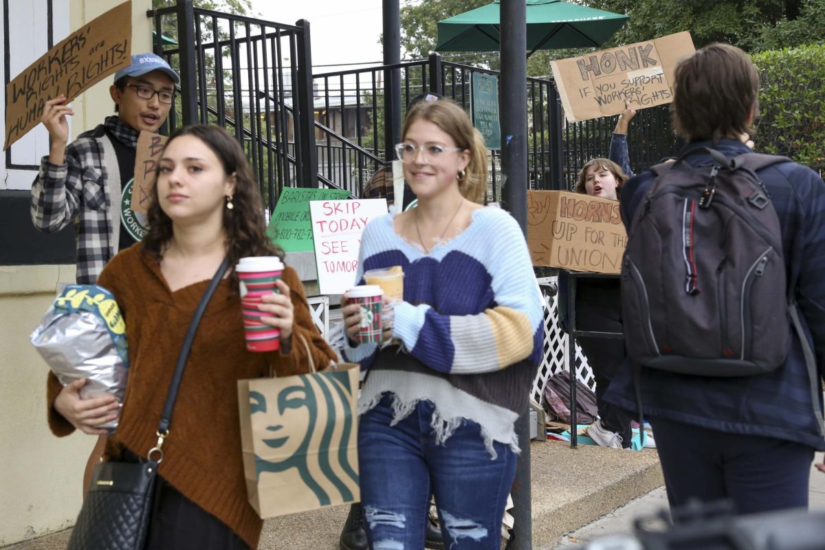 Starbucks customers walk past a picket line of Starbucks employees advocating for workers rights on Nov. 16, 2023. The employees chant, No contract? No coffee.