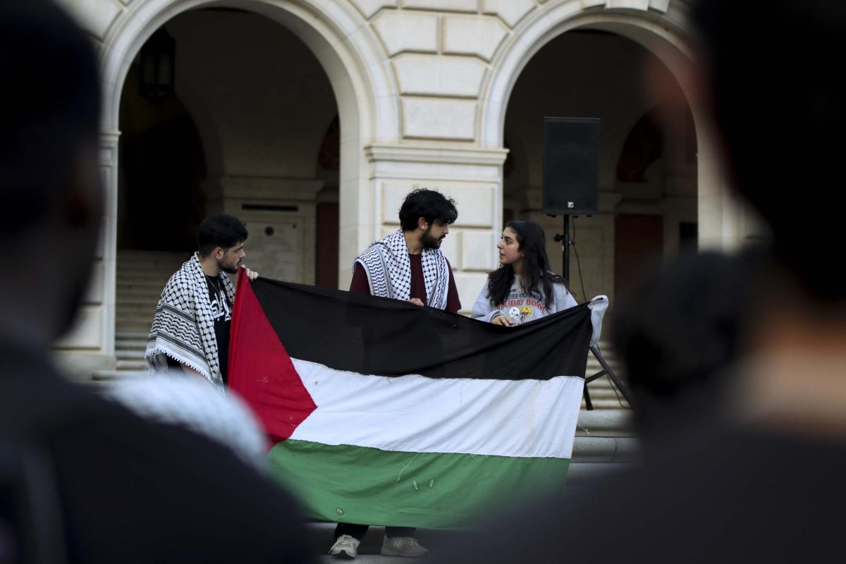 At the Emergency Vigil for Gaza on Oct. 26, 2023, organizers hold the flag of Palestine on the UT Tower steps.