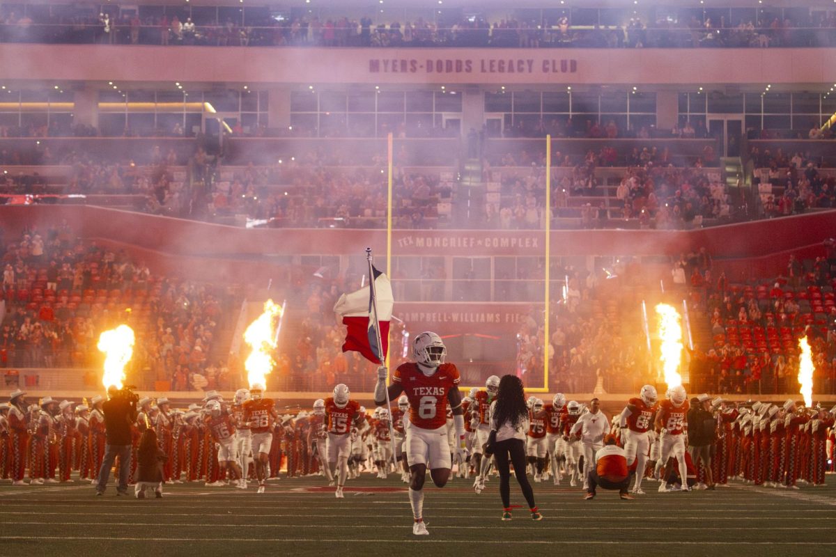 Defensive back Ryan Watts runs down the field with the Texas flag before Texas game against Texas Tech on Nov. 24, 2023.