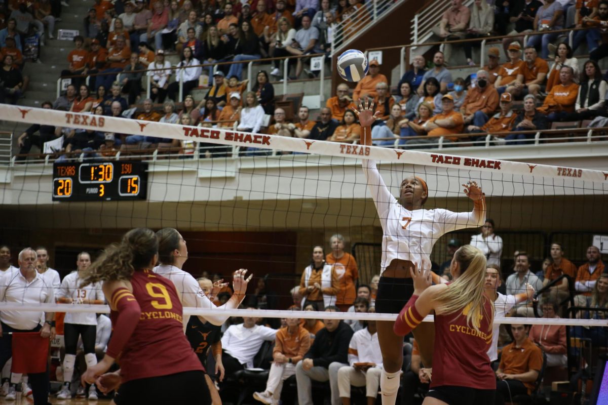 Senior middle-blocker Asjia O’Neal jumps spikes the ball toward the Iowa State volleyball team on Nov. 15, 2023. Texas won 3-1.