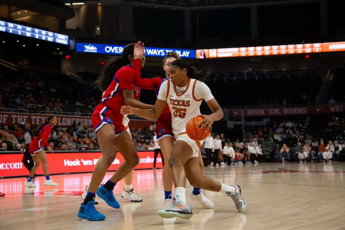Freshman point guard Madison Booker keeps the ball away from two Kansas players at Texass game against the Kansas on Jan. 16, 2024. Texas won 91-56.