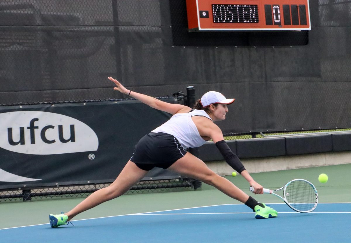 Junior Sabina Zeynalova lunges to hit the ball in singles play against Miska Kadleckova of Baylor University on January 26, 2024. Zeynalova was leading in the first set 6-5 when play stopped.