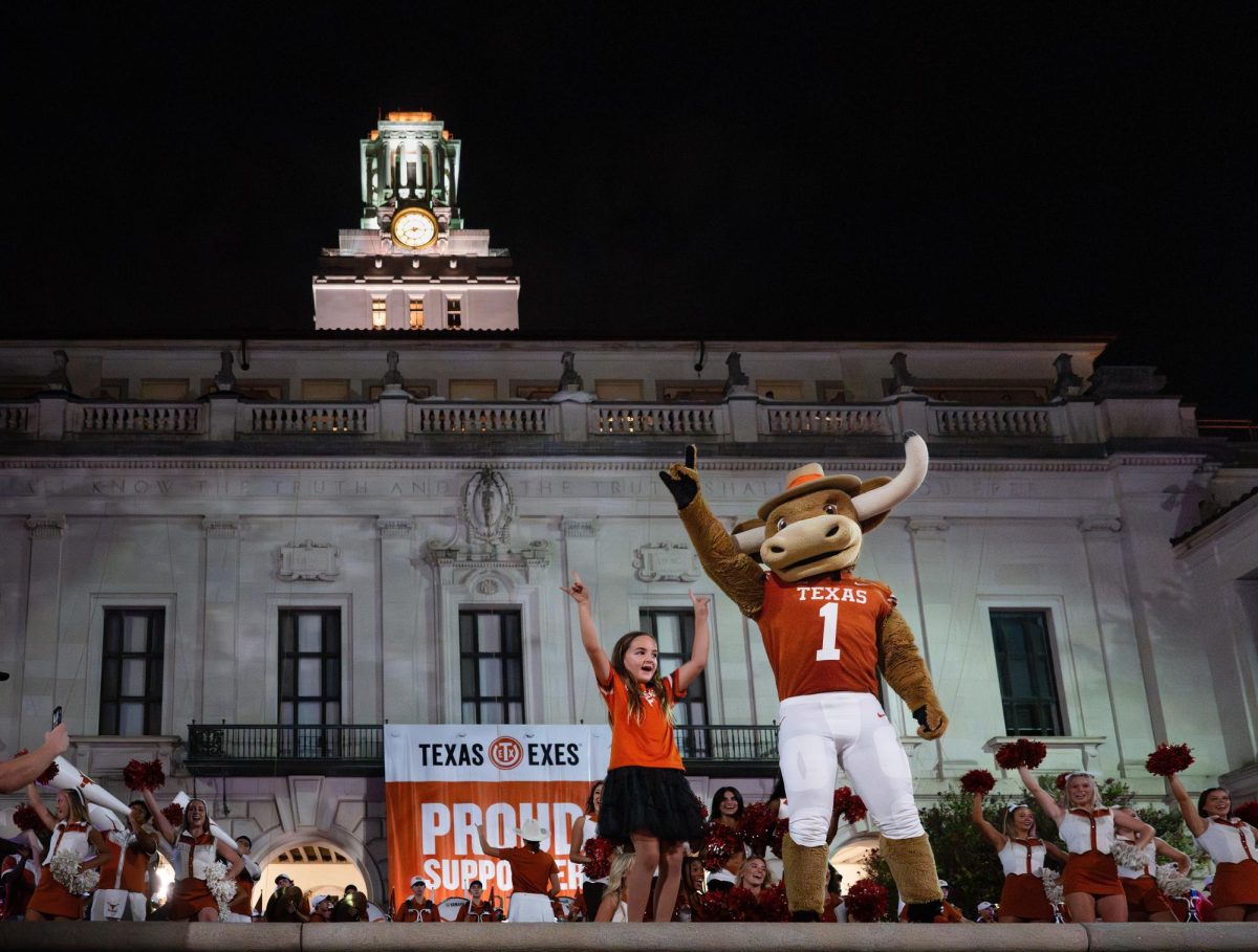 Texas mascot Hook Em cheering with a young fan at the Texas Fight Rally and Parade on Oct. 4, 2024. 