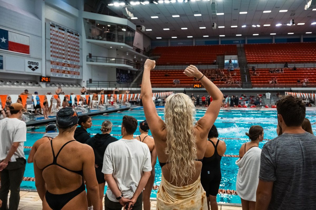 The mens and womens swim & dive teams cheer as their teammates compete against the University of Houston on Oct. 6, 2023.
