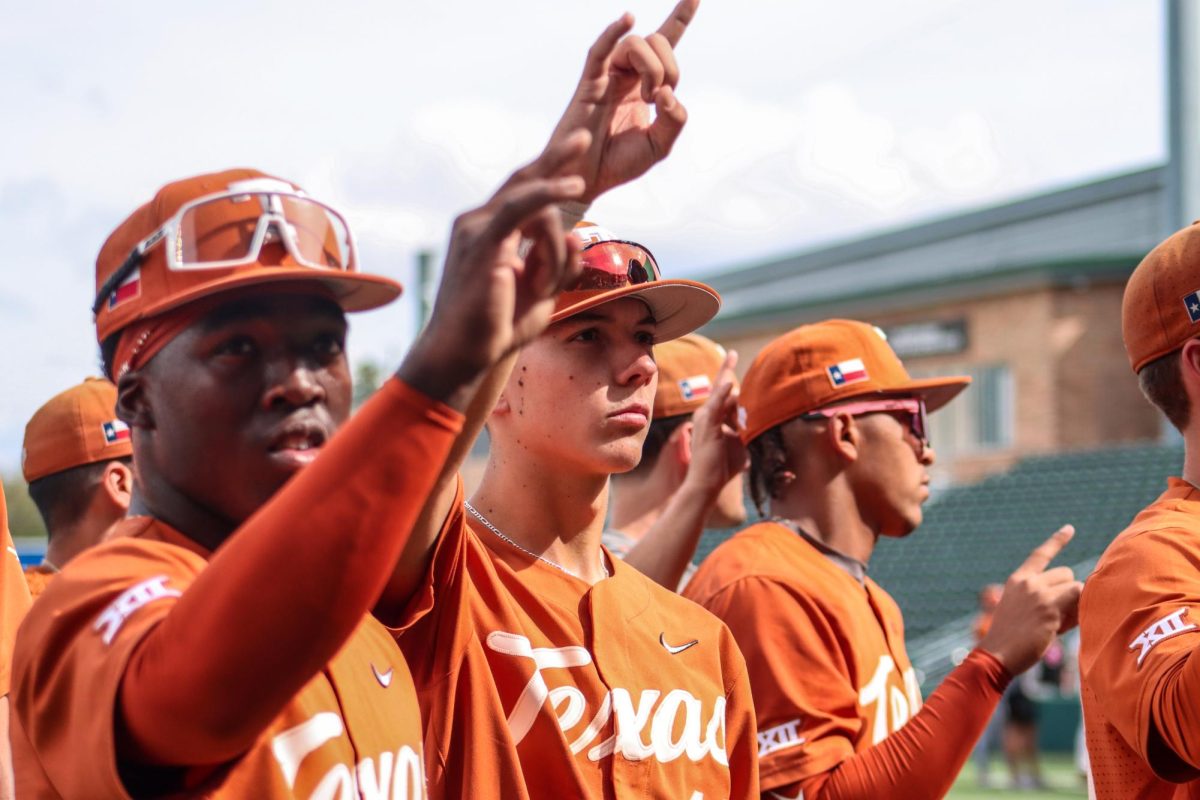 Freshmen Oliver Service and Sam Ardoin hold their horns up as The Eyes of Texas plays on November 5, 2023, before the third game of the Fall World Series begins.
