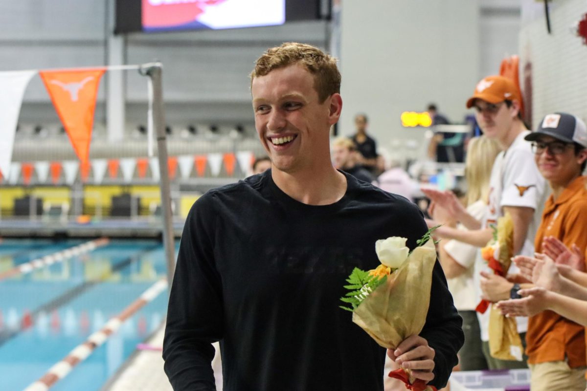 Fifth-year Jake Foster smiles after receiving a bouquet at the Senior Day swim meet vs. Texas Christian University on Feb. 2, 2024. Foster is a four time Honorable Mention All-American and during the week of this meet, was awarded Big 12 swimmer of the week.