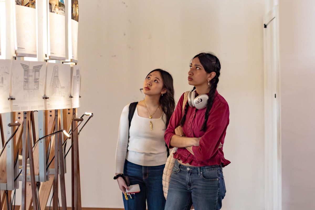 From left, advertising sophomore Emmy Chen and Anthropology and International Relations freshman Kylee Puga observe Biogenic House Sections in Mebane Gallery on Monday.